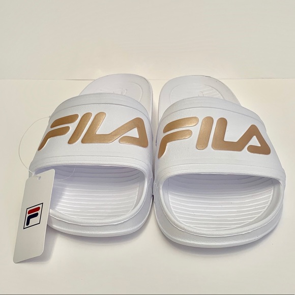 white and gold fila slides